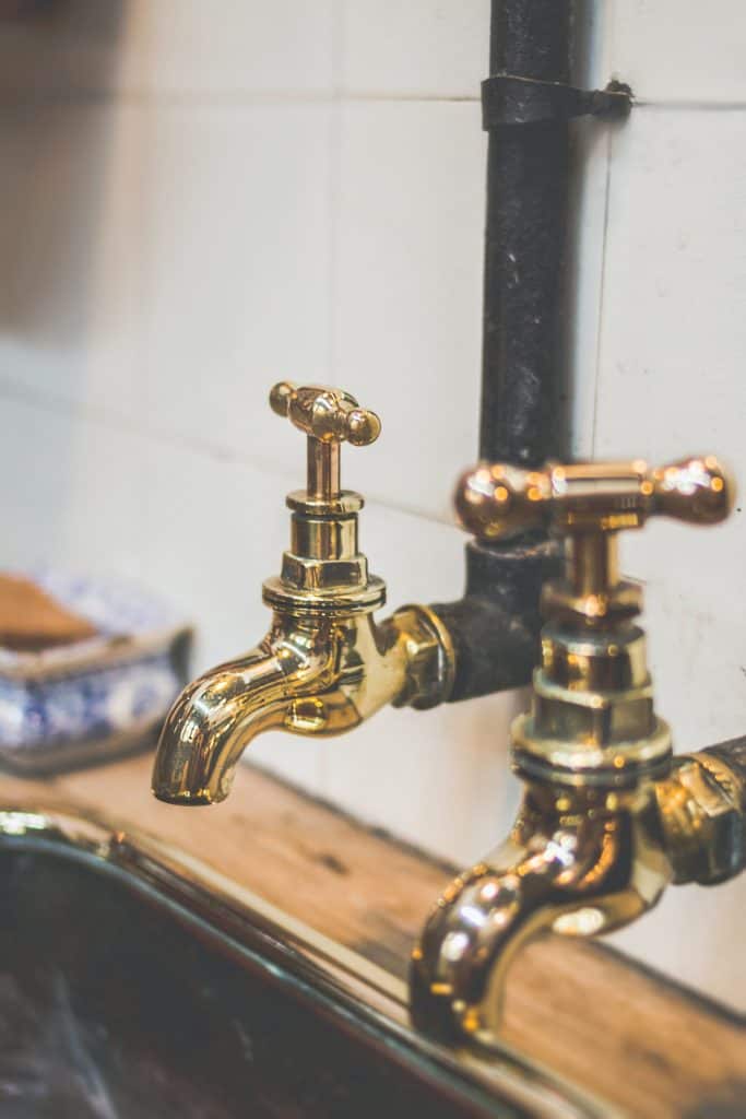 Shiny brass taps on a sink.